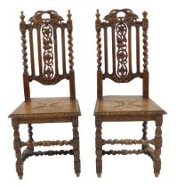 A pair of Victorian oak dining chairs in 17thC style, each with a pierced carved leaf and fruit back