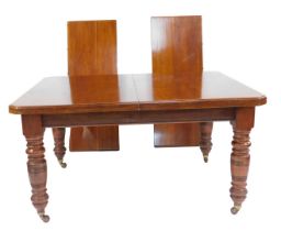 A Victorian mahogany extending dining table, the top with a moulded edge with canted corners, raised