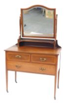 An Edwardian mahogany and cross banded dressing chest, the bevelled shaped mirror above a shelf, the