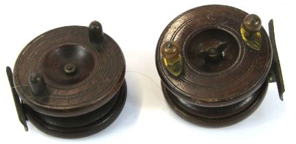 Two early 20thC wooden and brass fishing reels, each 9cm diameter.