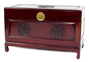 A Chinese cherry wood blanket chest, the rectangular top carved with a roundel depicting a flowering