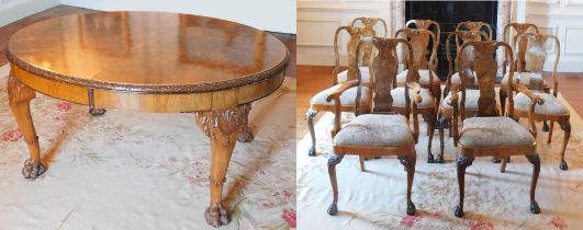 A George II style walnut extending dining table, the oval burr top with a carved edge, raised on fou