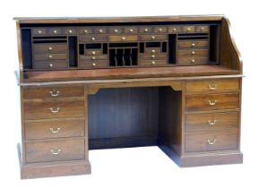 A 20thC oak roll top desk, the tambour front enclosing a dark red leatherette inset with an arrangem