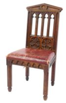 A Victorian oak chair in the Gothic style, the back with four pierced sections, above two floral mot