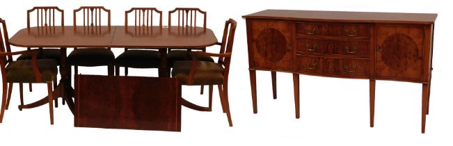 A 20thC reproduction yew wood veneered extending dining table, the rectangular top with a rounded co