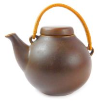 An Arabia pottery Oriental influence teapot, in brown glaze with a wicker handle, stamped to undersi