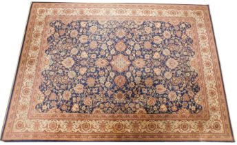 A Persian style machine woven rug, blue ground, decorated centrally with floral and leaf motifs, wit