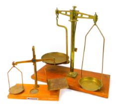 A set of A E Sommers & Co brass postal scales, on an oak base, 26cm high, together with a larger set