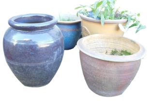 Four garden plant pots, of differing sizes, designs and colour palettes.