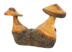 A wooden garden sculpture modelled as two toadstools, 46cm high, 61cm wide.