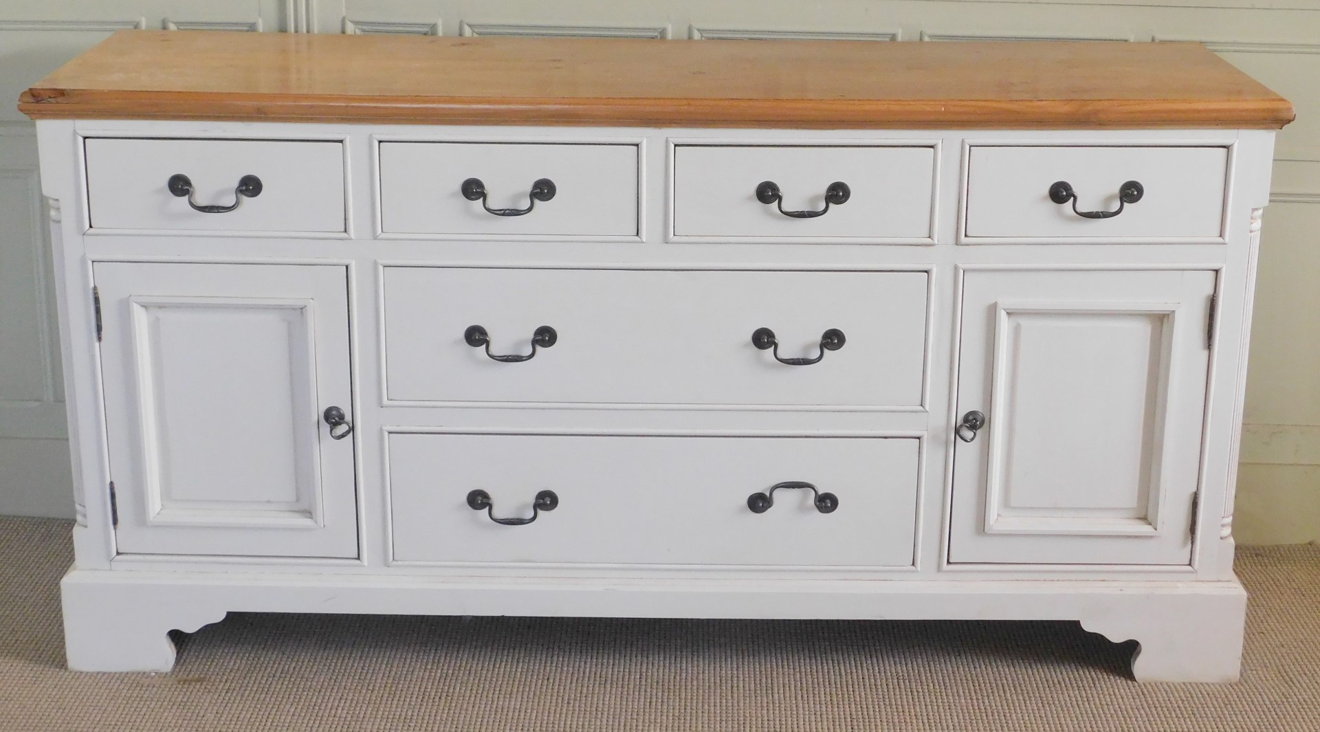A modern pine and cream painted sideboard, the top with a moulded edge above four short drawers abov