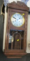 An oak cased wall clock, with silvered circular dial bearing Arabic numerals, eight day with pendulu