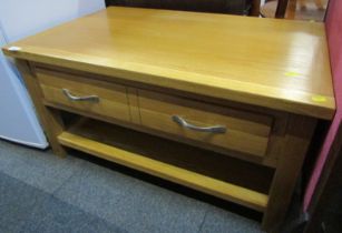 An oak coffee table, the rectangular top above two drawers, with an under tier, on stiles, 46cm high