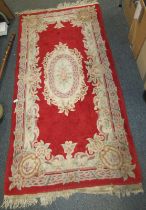 A Chinese red ground wool cut rug, 184cm x 92cm.