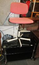 A glass three tier television stand, together with a Rabami machinist or office type chair. (2)