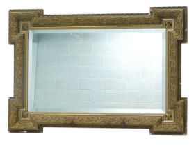 A gilt gesso wall mirror, the frame moulded with scrolls, etc., with a bevelled plate, 75cm high, 10