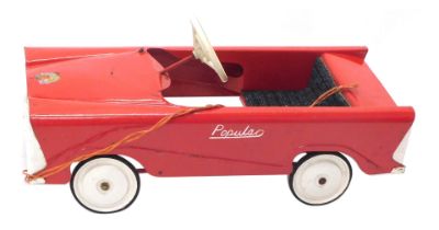 A Popular red painted pedal car, with cream coloured fender, wheel hubs, etc.