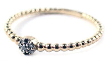 A dress ring, on beaded band with central cluster set with white stones, ring size P.