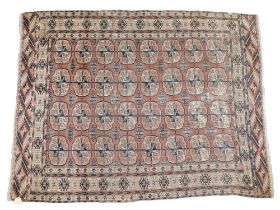 A Turkoman rug, with a design of medallions, on a red ground, 119cm x 142cm. (AF)