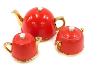 A Beverley three piece Art Deco tea service, with red coloured metal covers, the teapot, 22cm wide.