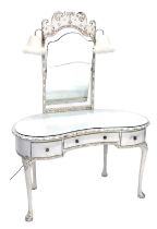 A cream painted kidney shaped dressing table, the raised back with a rectangular mirror plate, with