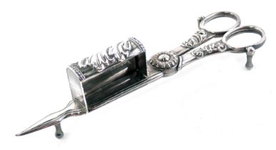 A pair of 19thC Continental candle snuffers, decorated with scrolls, etc., 17cm long.