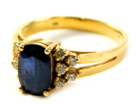 A sapphire and diamond dress ring, the oval cut sapphire in four claw setting, with five tiny diamon