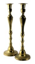 A large pair of turned brass candlesticks, each with a domed foot, 57cm high.