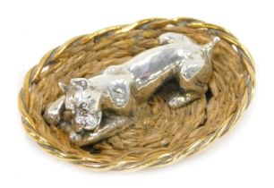 A 20thC silver miniature model of a dog in a basket, with woven sides, indistinct makers stamp, stam