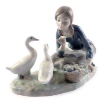 A Lladro porcelain model of a lady feeding geese, on oval base, 23cm wide, boxed.