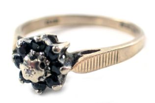 A 9ct gold floral cluster dress ring, set with eight sapphires and central platinum star, ring size