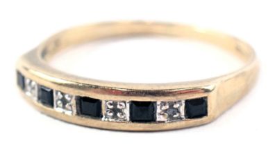 A 9ct gold half hoop dress ring, the panel set with five sapphires and four tiny diamonds, in platin