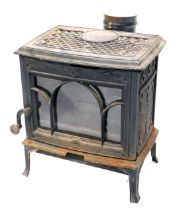 A cast iron wood burning stove, with single glass door, indistinct maker, 51cm wide. (AF)