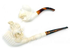 A Turkish Meerschaum pipe, carved with a figure riding a donkey, and another similar of a man wearin