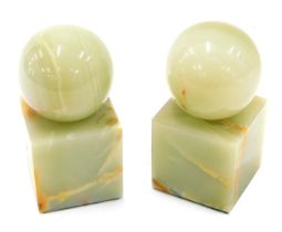 A pair of green onyx book ends, each with a spherical top and a square base, 13cm high.
