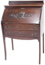 A late 19thC Continental mahogany bureau, with a raised back above a fall, carved with a mask and sc