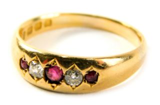 An 18ct gold ruby and diamond dress ring, with three illusion set rubies and two diamonds, ring size