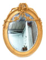A 19thC gilt gesso oval wall mirror, embellished with swags, ribbons, etc., with a bevelled plate an