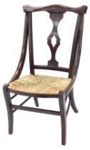 A late 19th/early 20thC country made side chair, with a pierced splat and a rush seat, on sabre legs