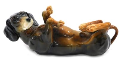 A Karl Ens ceramic dachshund, rolling with Ens stamp to underside, 21cm wide.