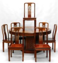 A Chinese hardwood dining suite, comprising table with circular panelled top with a frieze carved wi