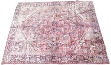 A Persian Heriz carpet, with a central pole medallion on a rust coloured red ground with cream spand