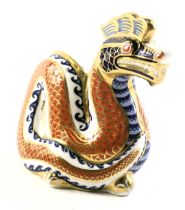 A Royal Crown Derby porcelain dragon paperweight, lacking button, red back stamp, 12cm high.