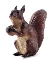 A cast metal figure of a seated squirrel, carrying nut, 7cm high.