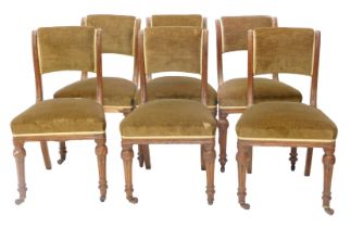 A set of six early Victorian oak dining chairs, each with a green upholstered padded back and seat o