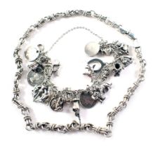 A charm bracelet, on curb link bracelet with coin and figure drops, stamped 925, and a fancy link ch