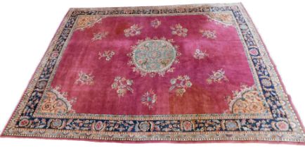 An Indian rug, with a design of flowers, etc., on a purple ground with one wide and three narrow bor