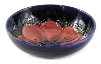 A Moorcroft small bowl, on a Royal blue ground with Pink Pansy pattern, 11cm diameter.