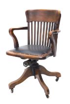 An early 20thC walnut office chair, with a slatted back, padded seat, on X shaped base.