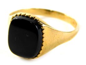 A 9ct gold signet ring, with black polished onyx, with a petalated border on a plain band, ring size